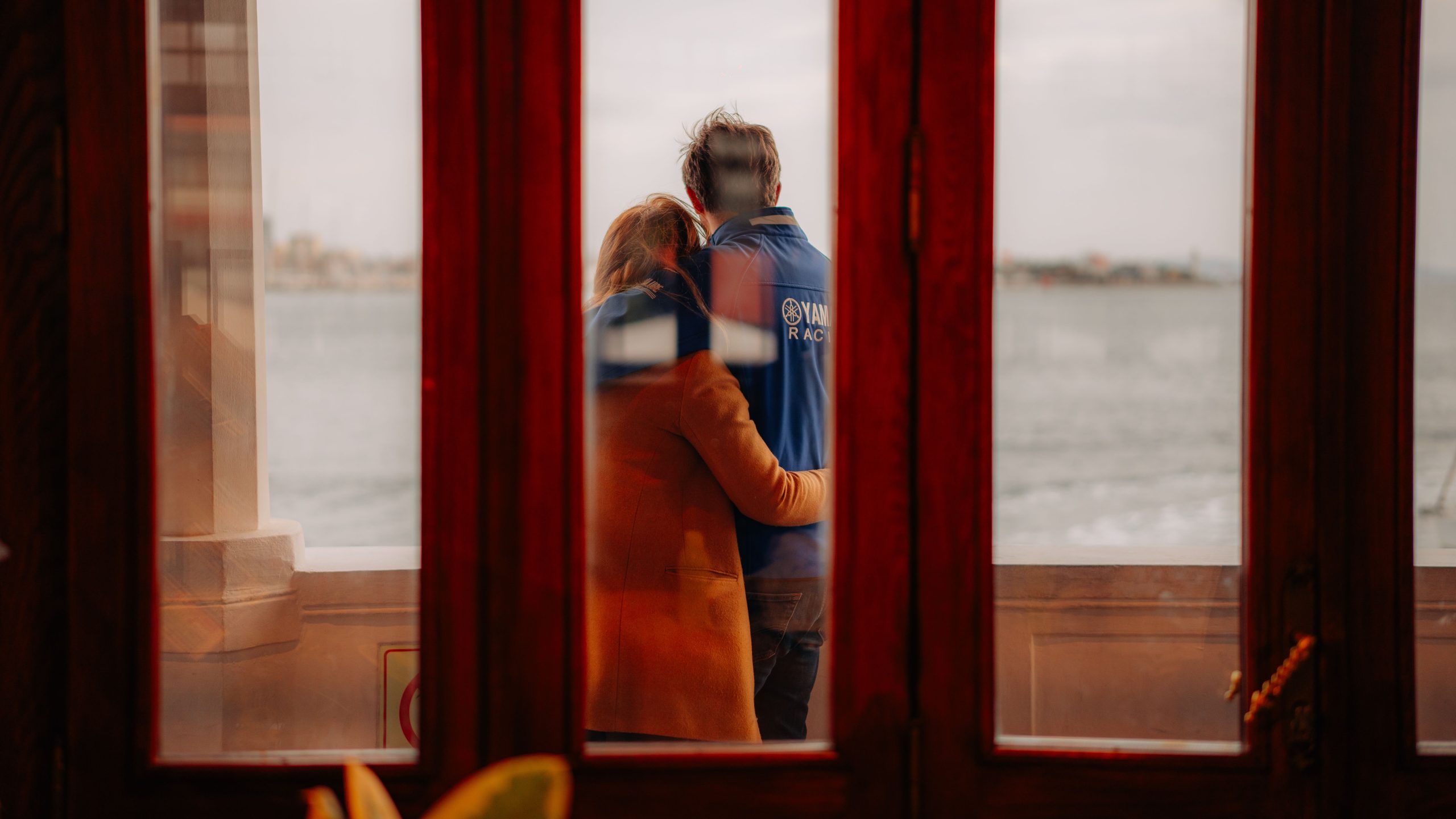 Couple s'embrassant près de la mer par fenêtre