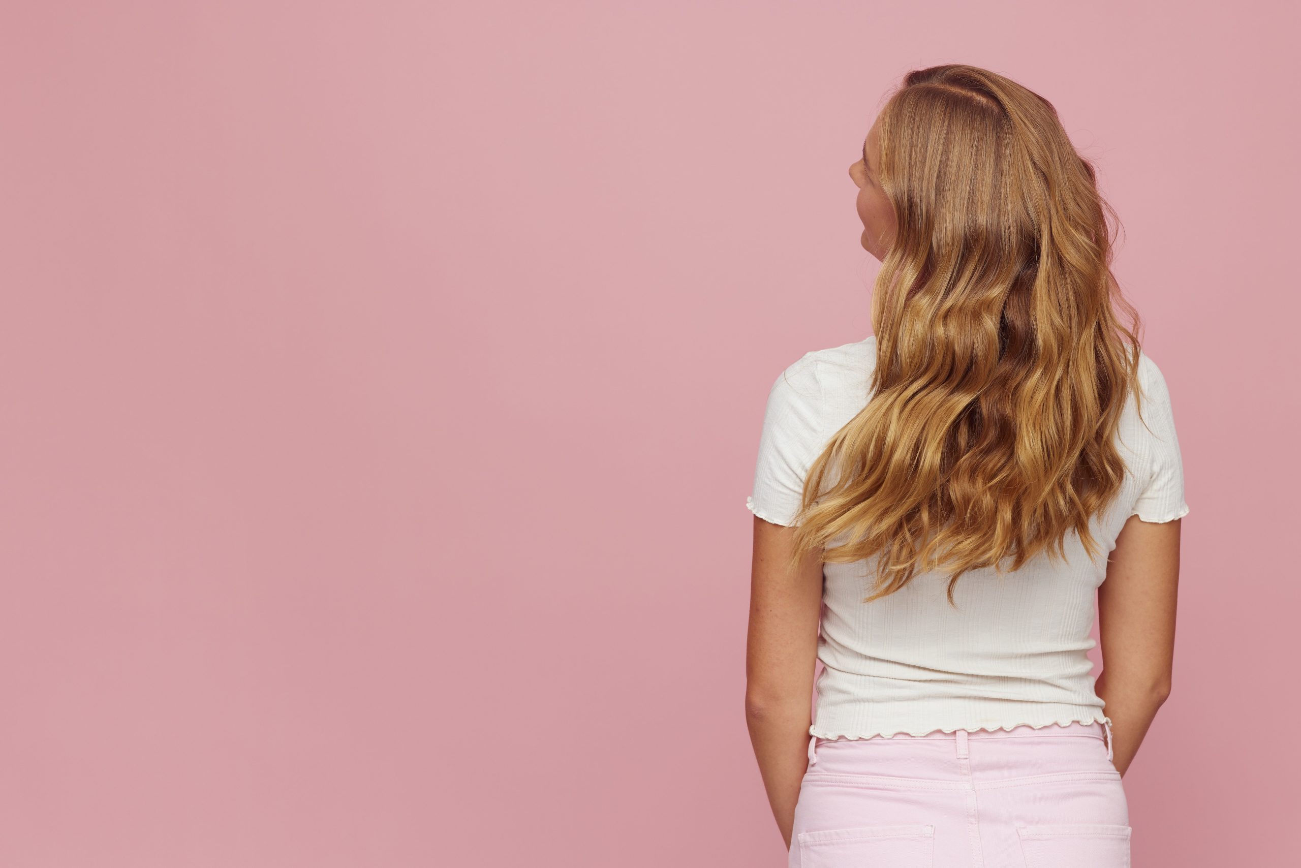 Femme blonde aux cheveux ondules de dos