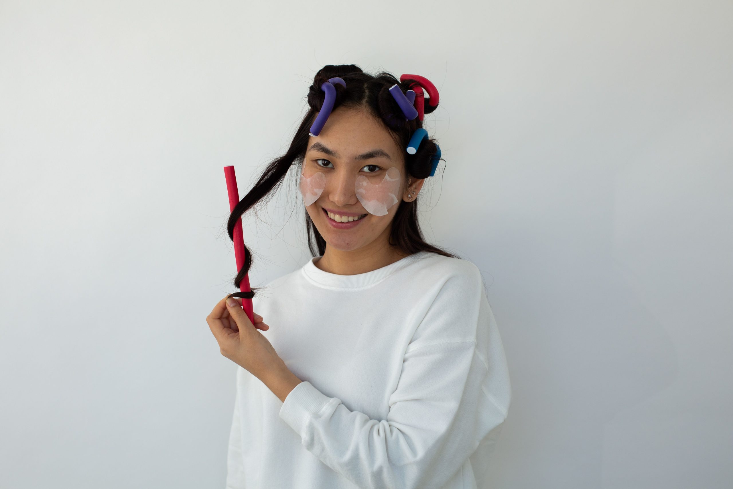 Femme asiatique avec rouleaux cheveux et masque
