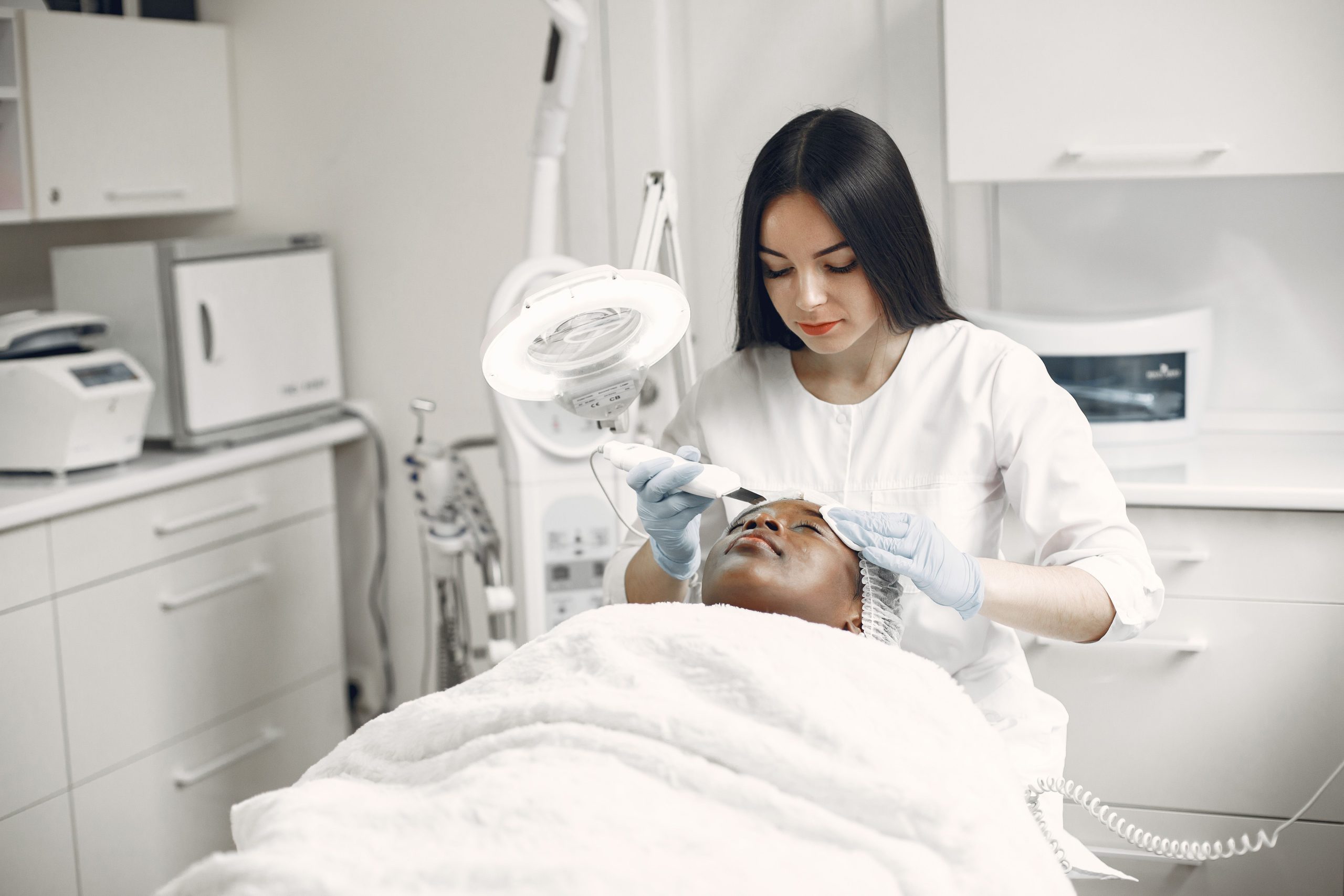 Estheticienne prodiguant soin facial rajeunissant spa