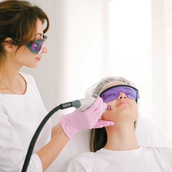 Cosmetologue effectuant traitement laser en clinique