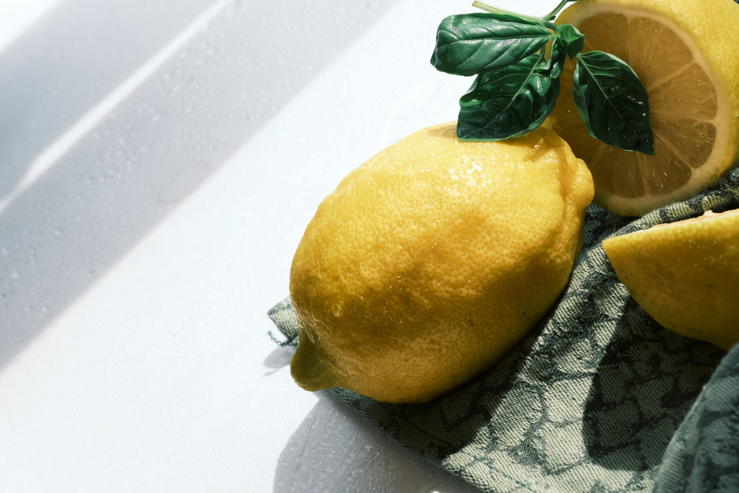 Citrons frais avec feuilles de basilic en lumière