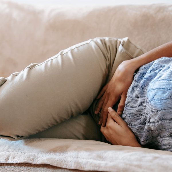 Femme allongée sur canapé souffrant douleur estomac