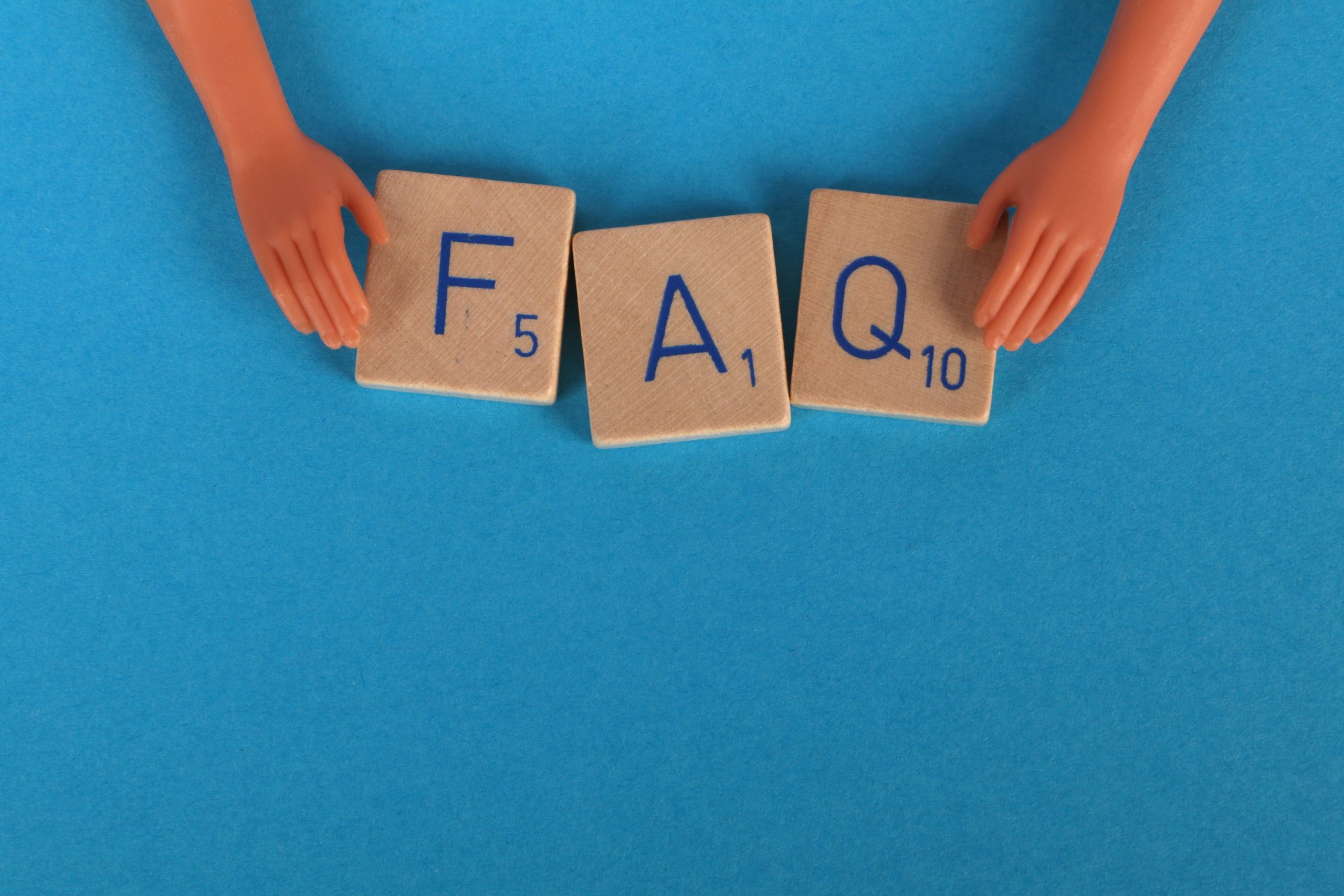 Tuiles scrabble épelant FAQ sur fond bleu