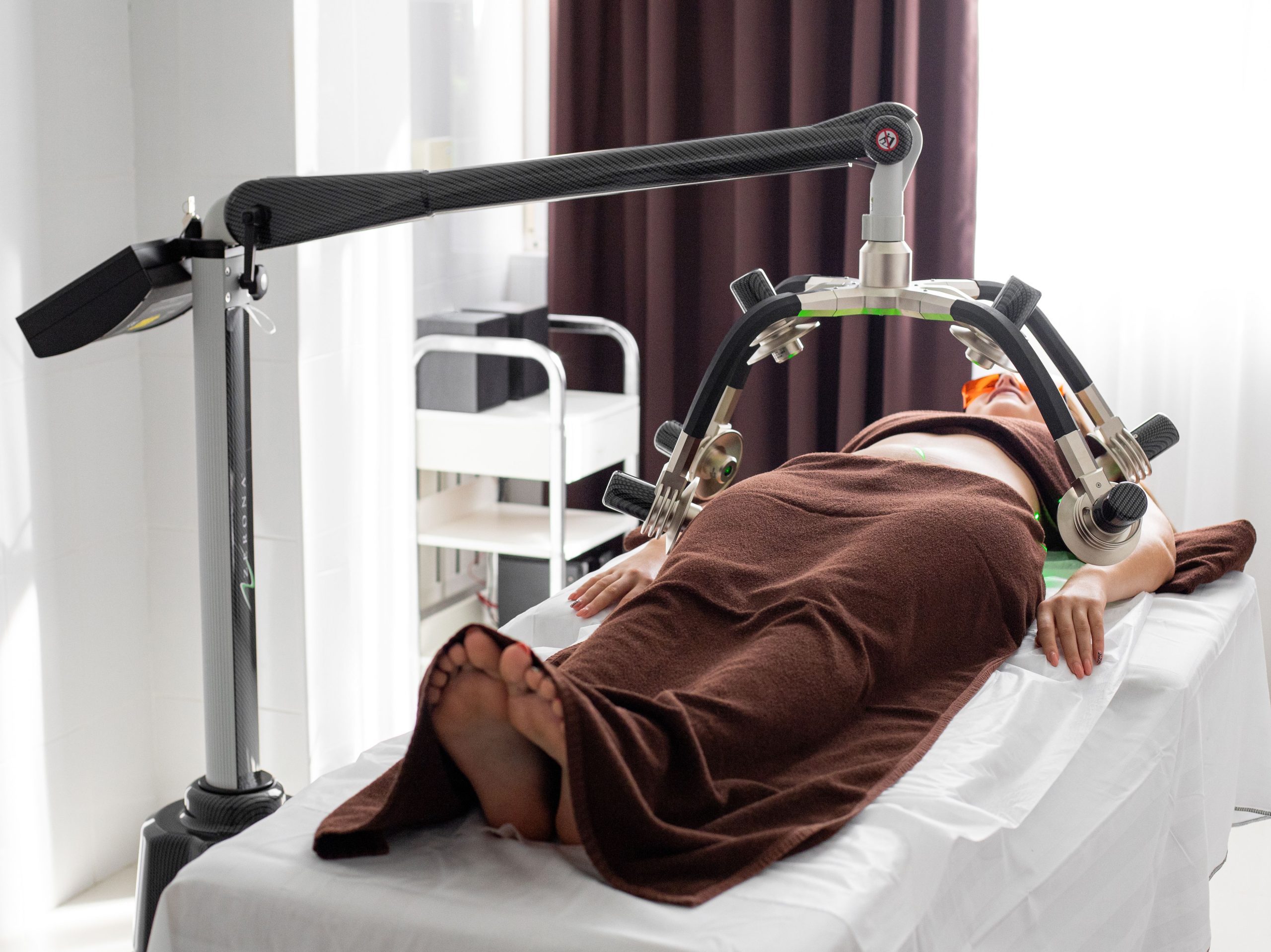 Femme sous appareil cryolipolyse en cabinet médical