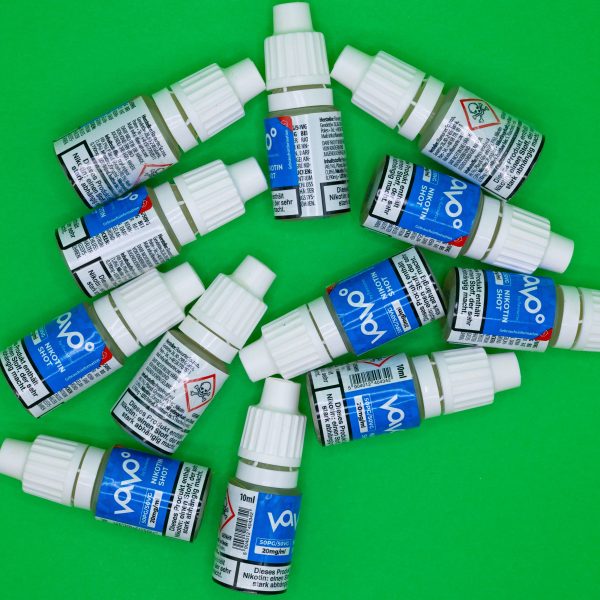 Plusieurs flacons de booster nicotine sur fond vert