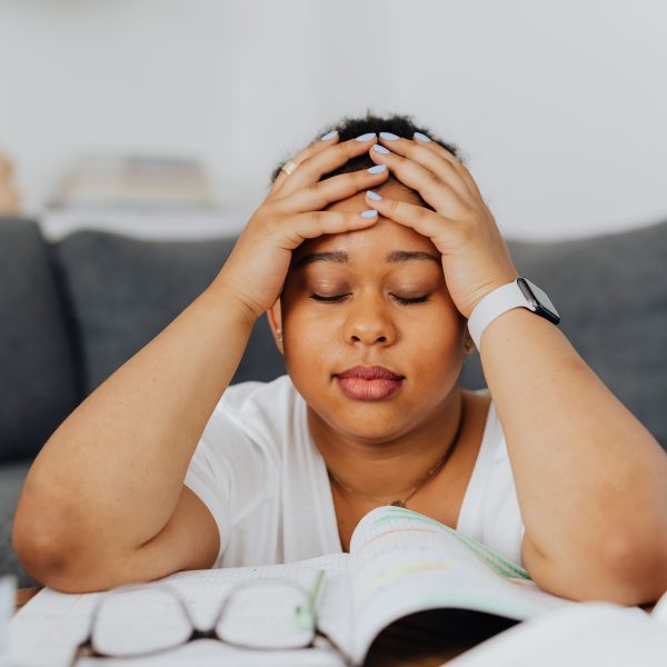 Femme stressée se tenant la tête près de livres