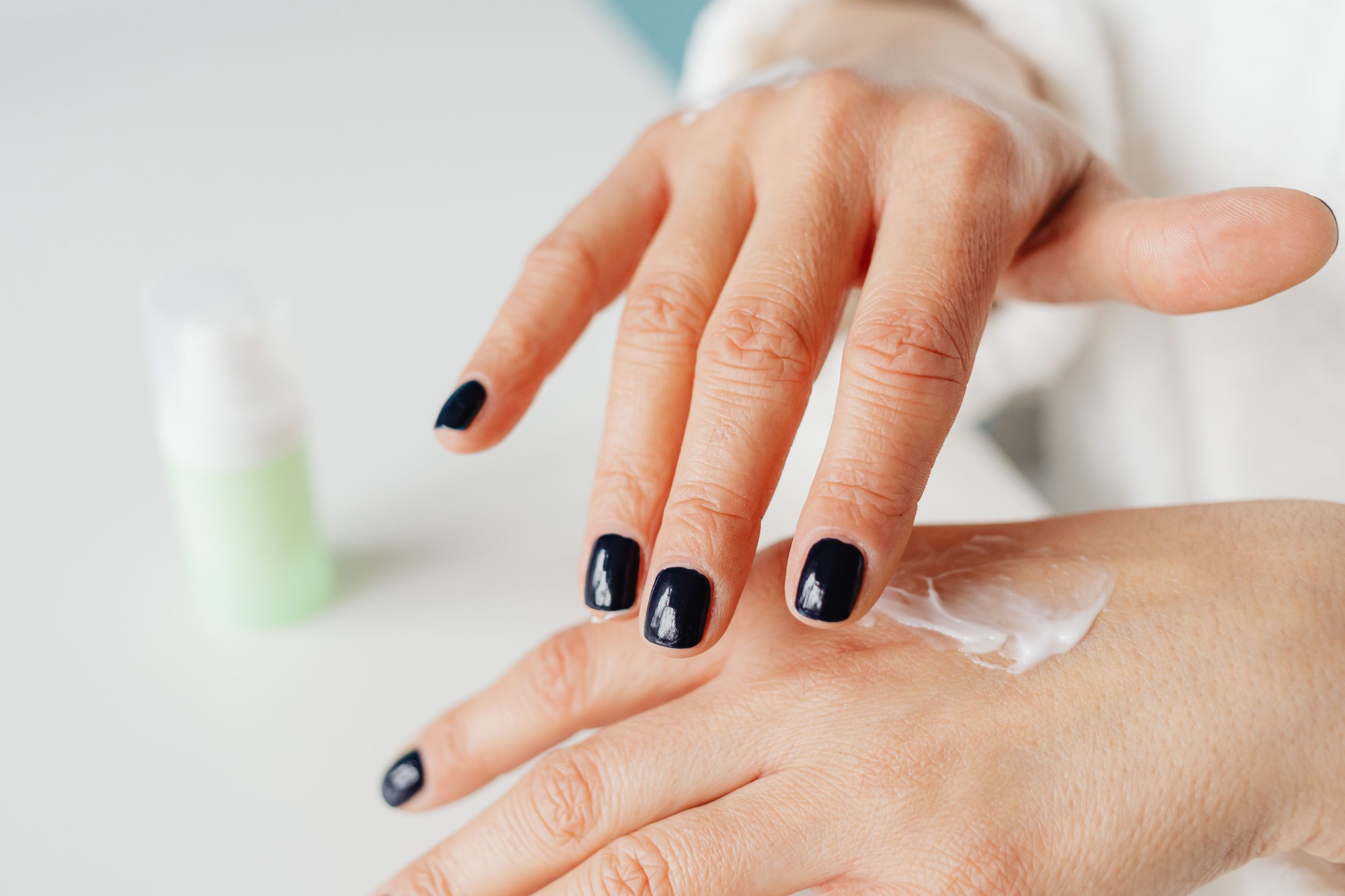 Femme appliquant une crème hydratante sur les mains