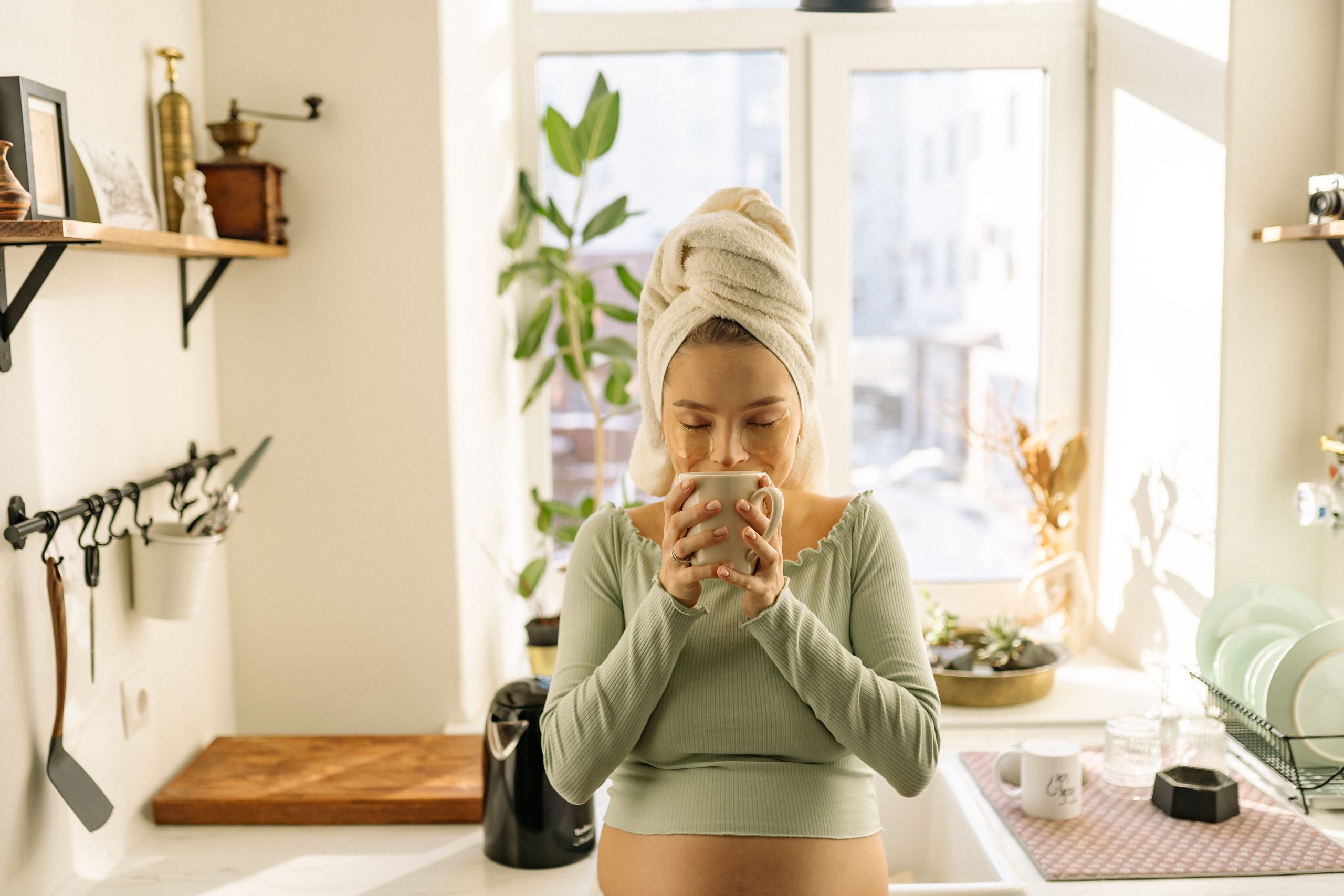 Femme enceinte relaxant avec du thé en lumière naturelle