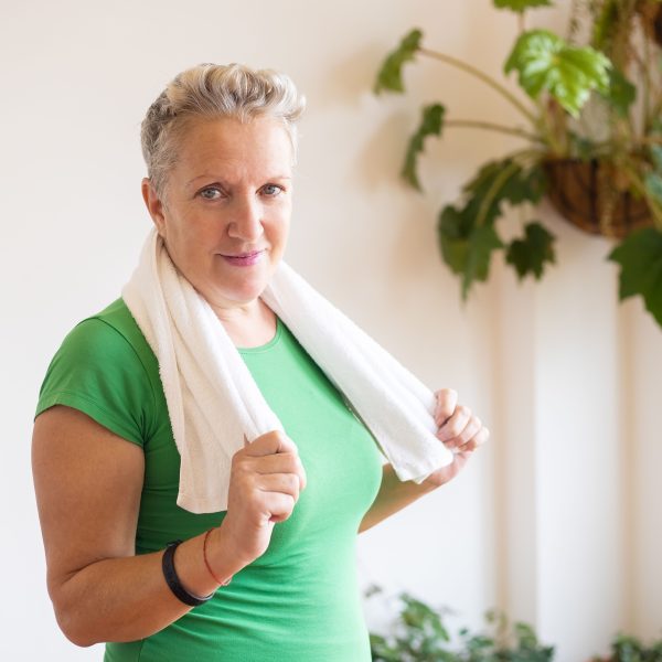 Femme senior active en tenue verte avec serviette