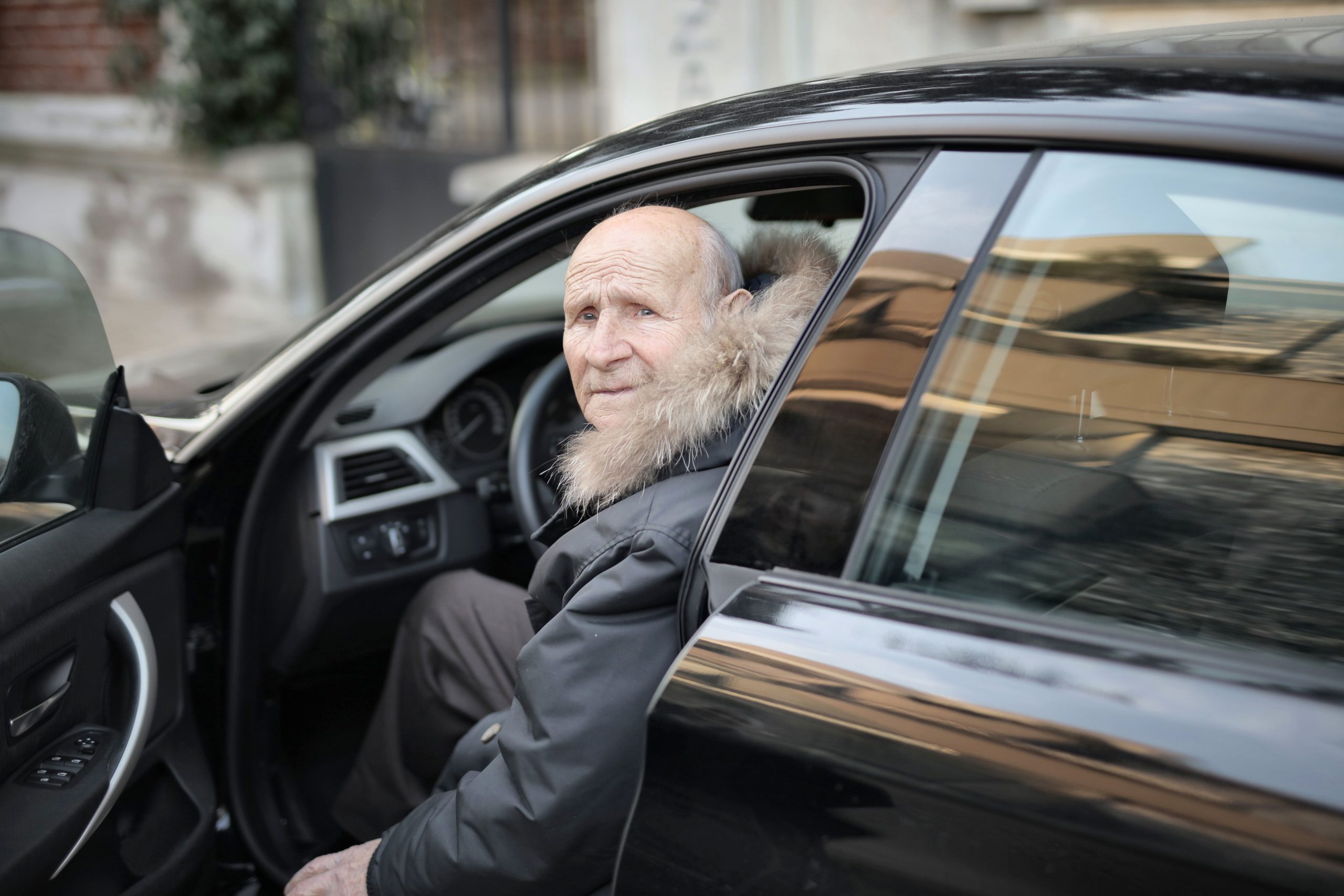 Homme âgé sortant d'une voiture garée