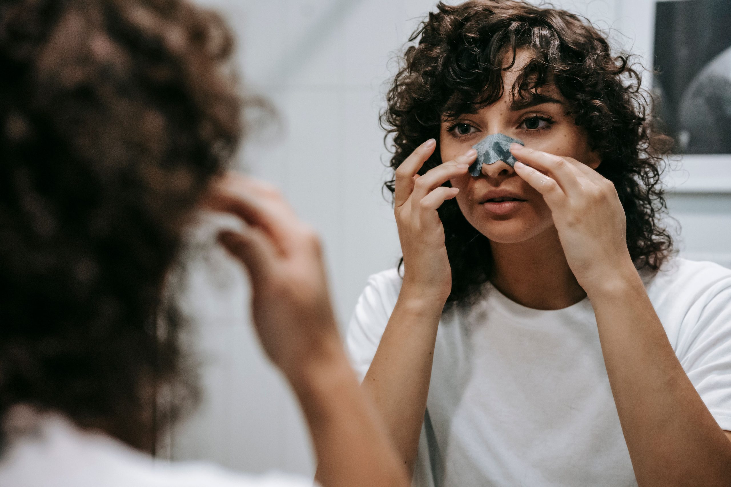 Femme appliquant masque argile sur le nez