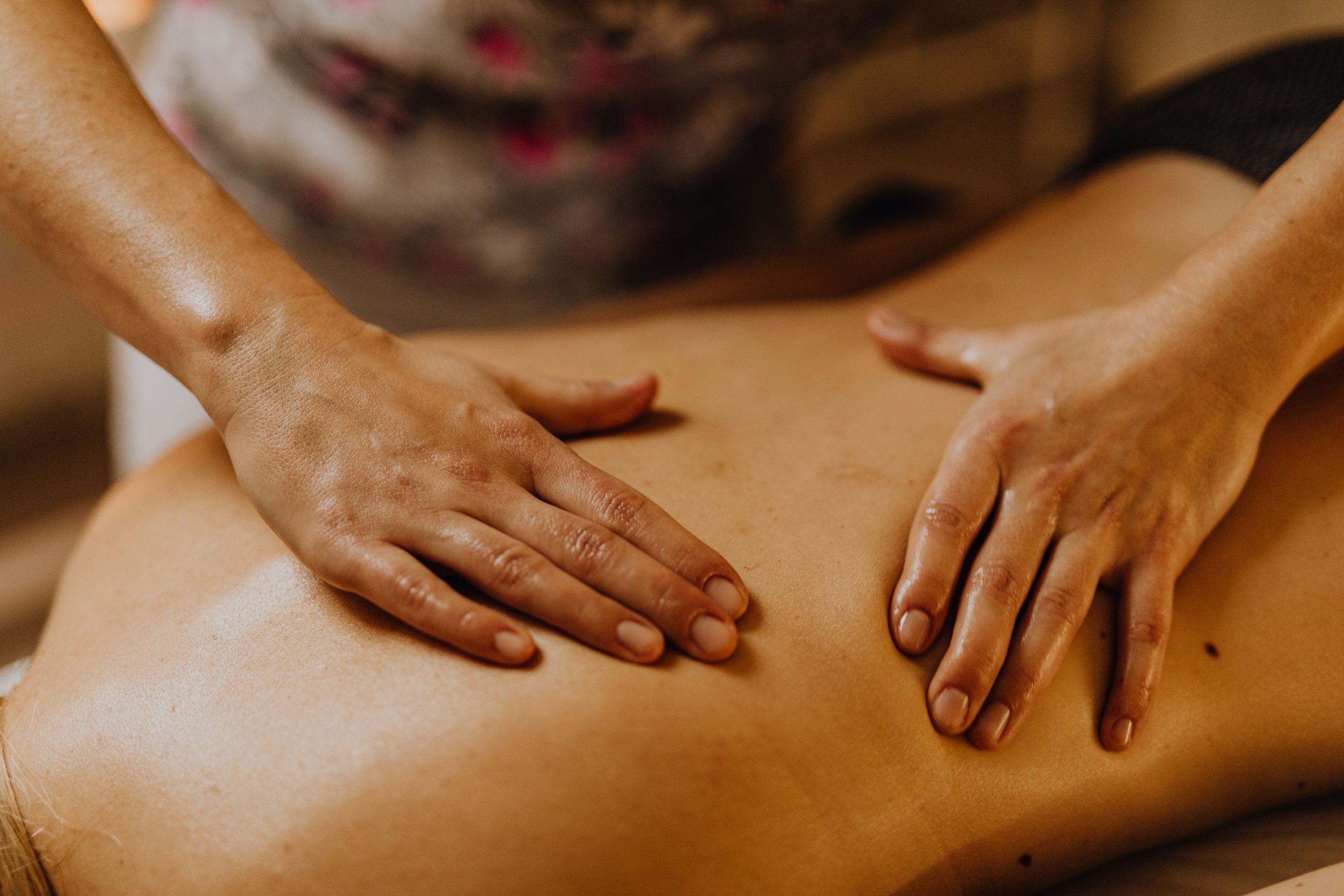 Mains prodiguant massage apaisant du dos.