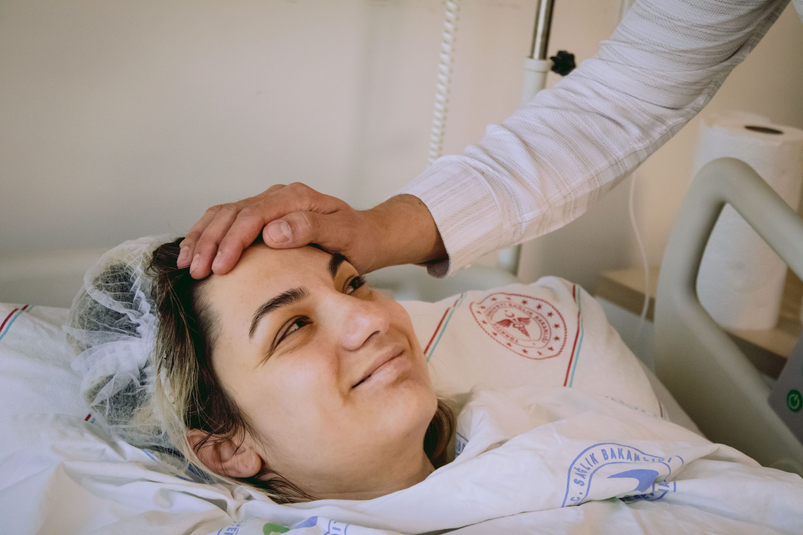 Femme souriante au lit avec soutien bienveillant