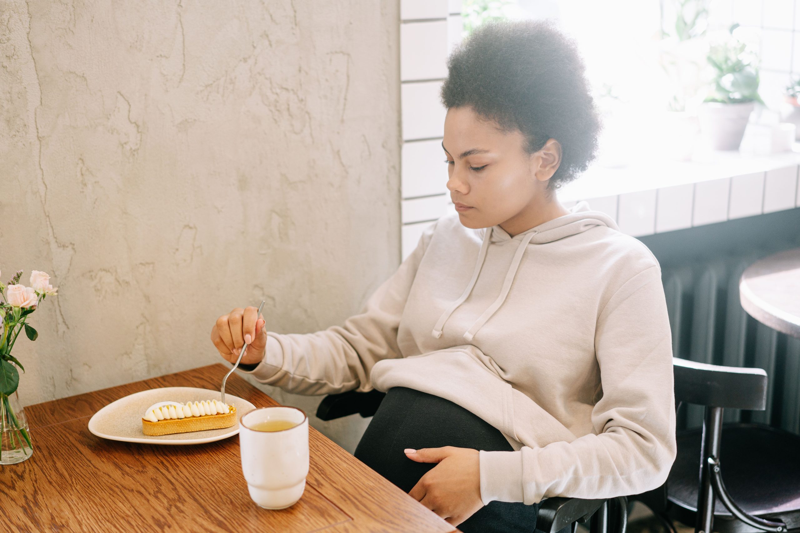 Femme enceinte sereine dégustant une boisson chaude apaisante