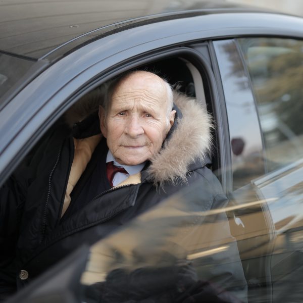 Homme senior conduisant une voiture en hiver