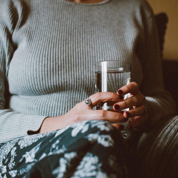 Femme tenant un verre d'eau calme et détendue