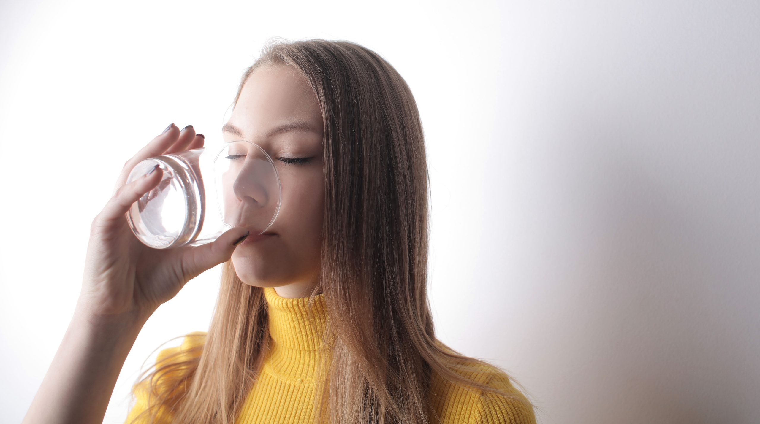Femme élégante boit eau pure intérieur