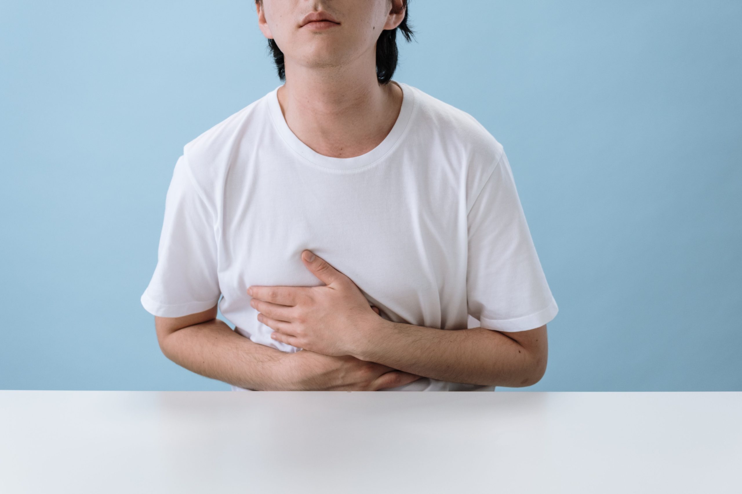 Homme en chemise blanche, douleur abdominale