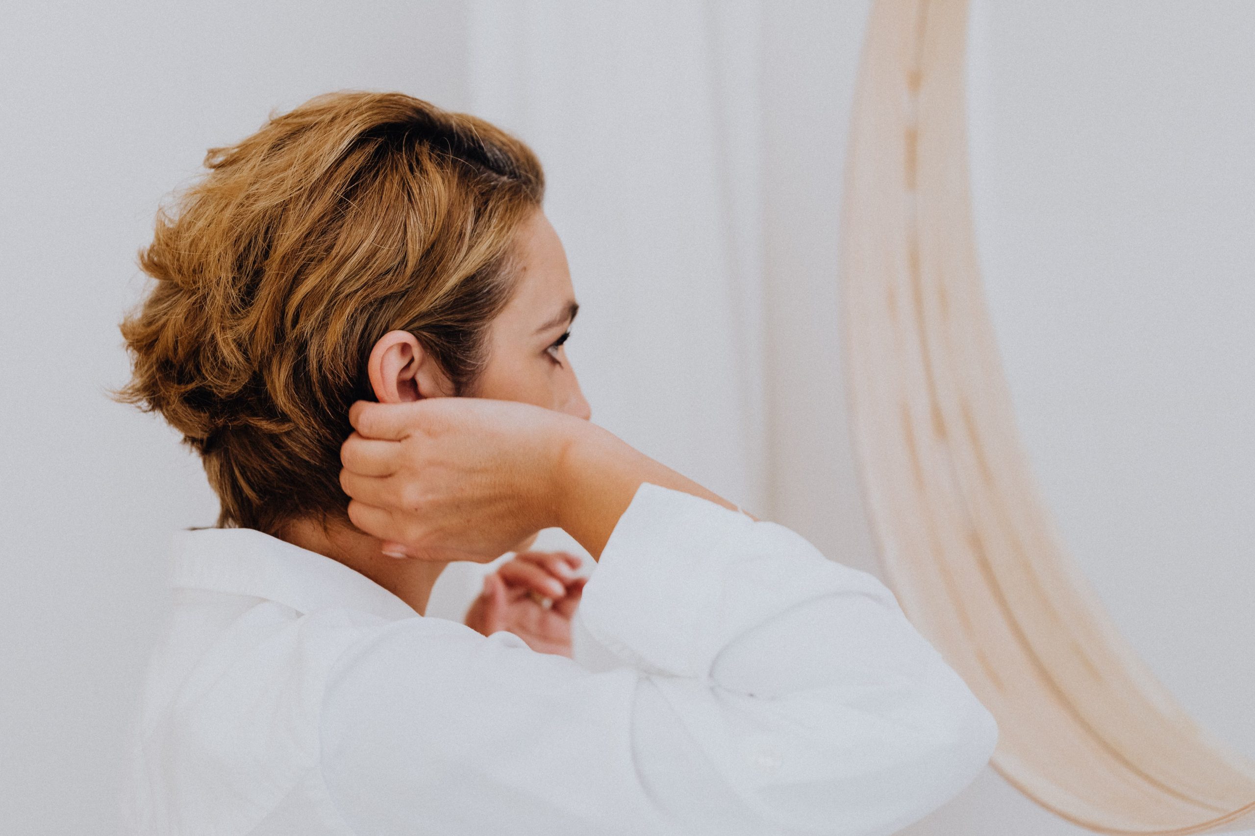 Femme ajuste sa coiffure courte devant le miroir